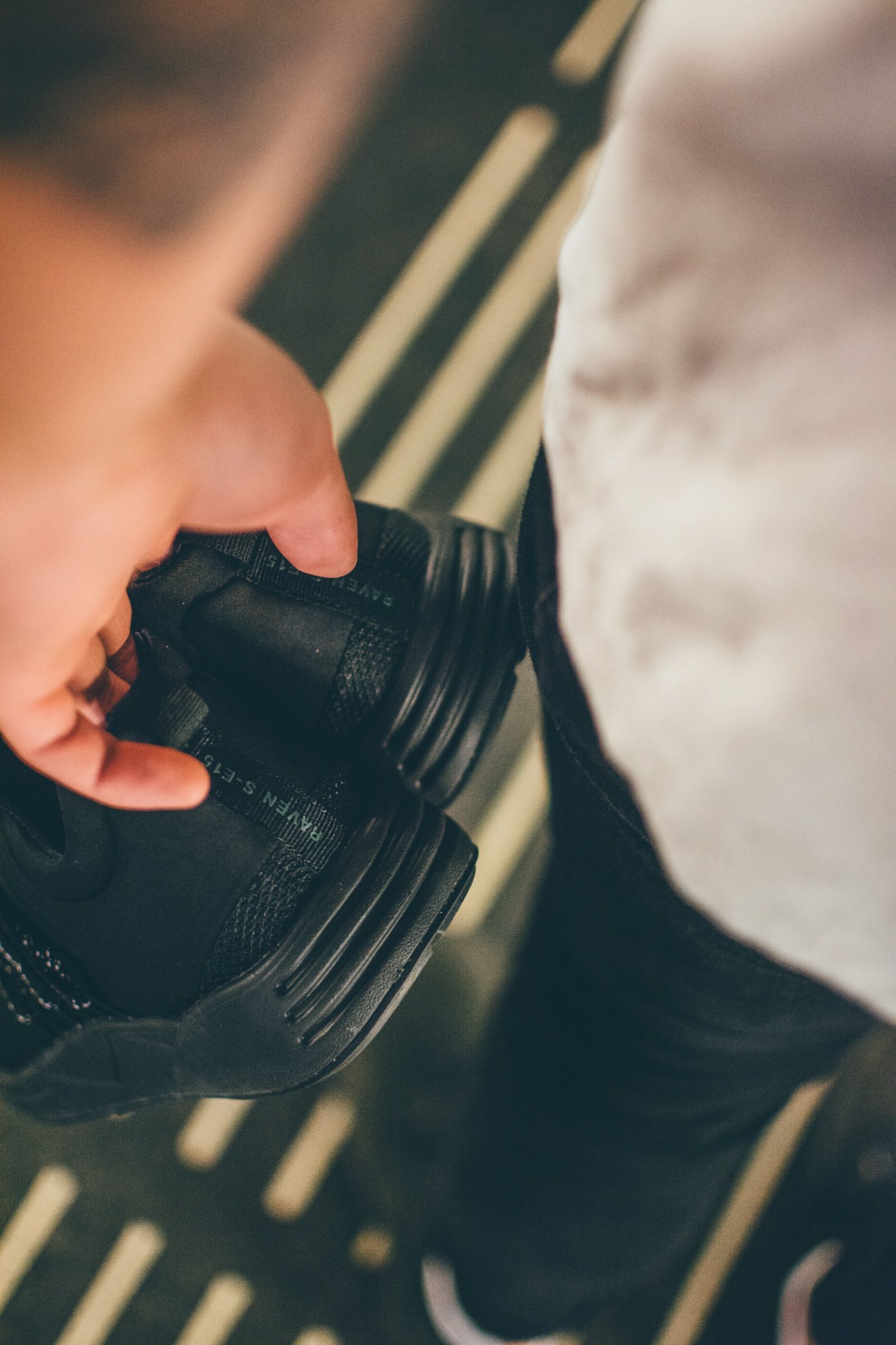 Black ARKK sneakers held in both hands
