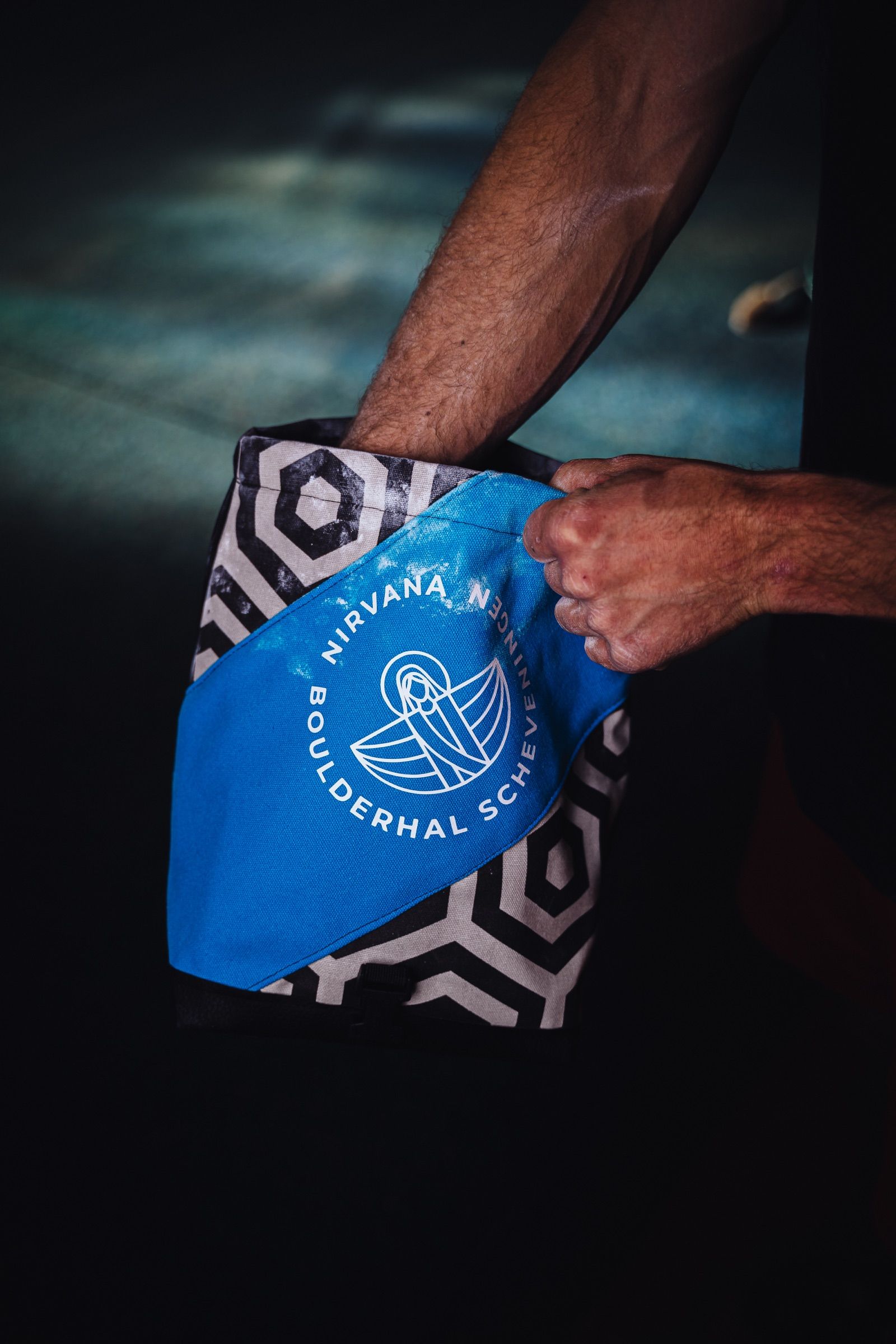 Climber reaching into a chalk bag at Boulderhal Nirvana