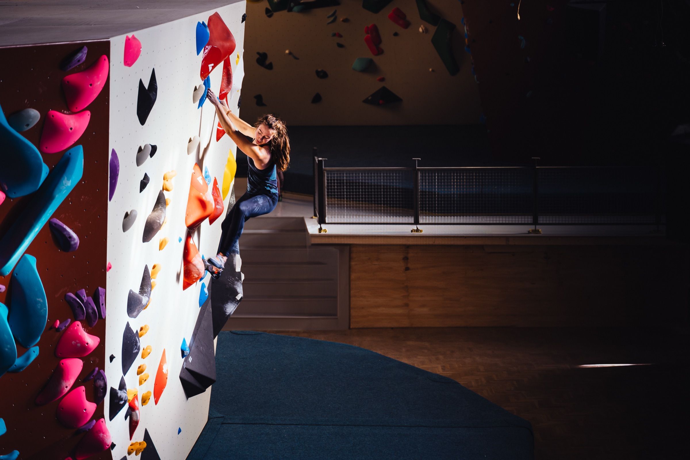 Climber high on a wall looking down in the gym