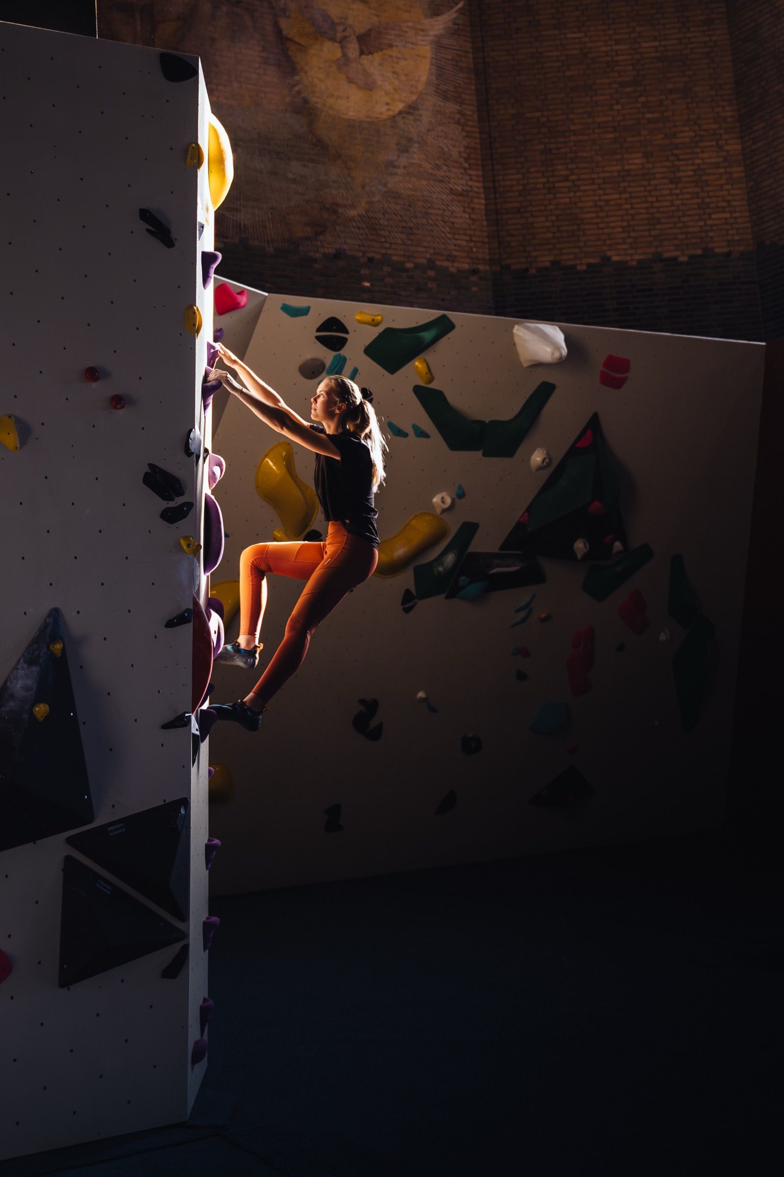 Climber on a wall inside the former church bouldering gym