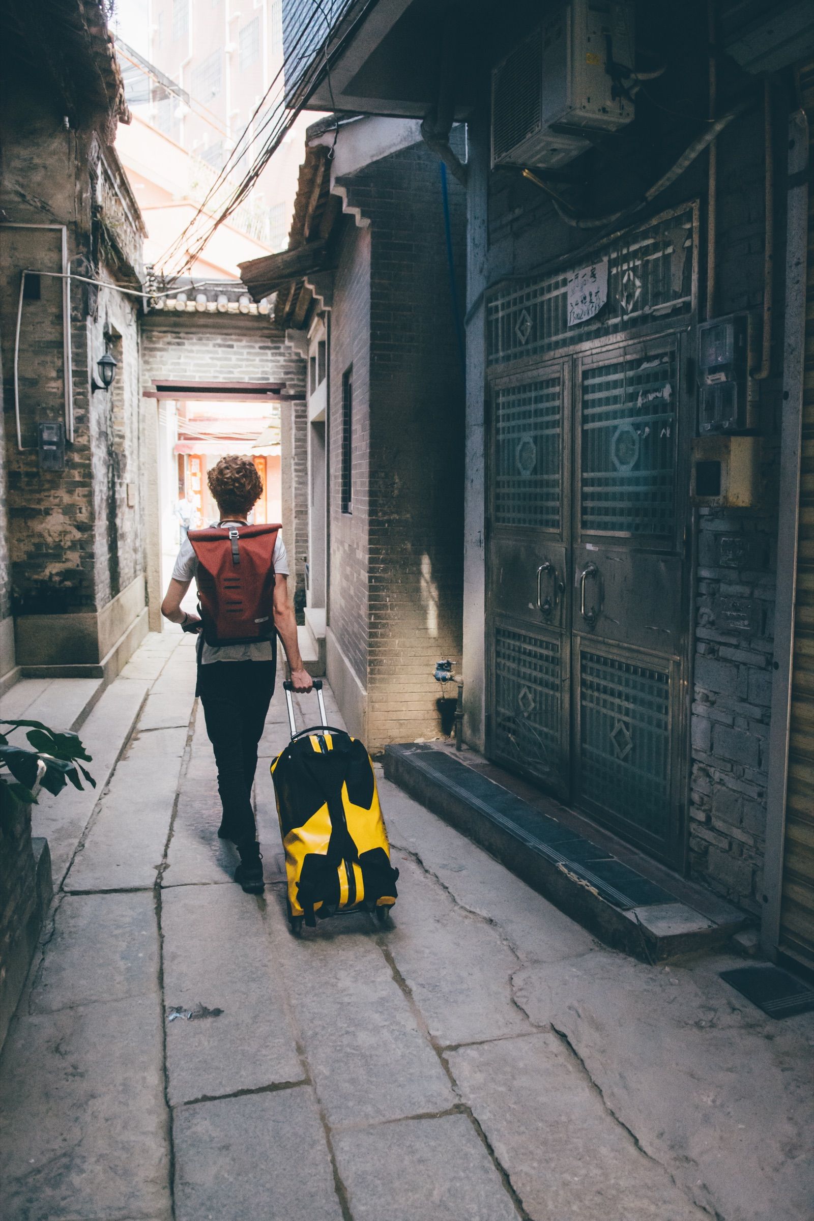 Traveler with an Ortlieb backpack in a narrow alley