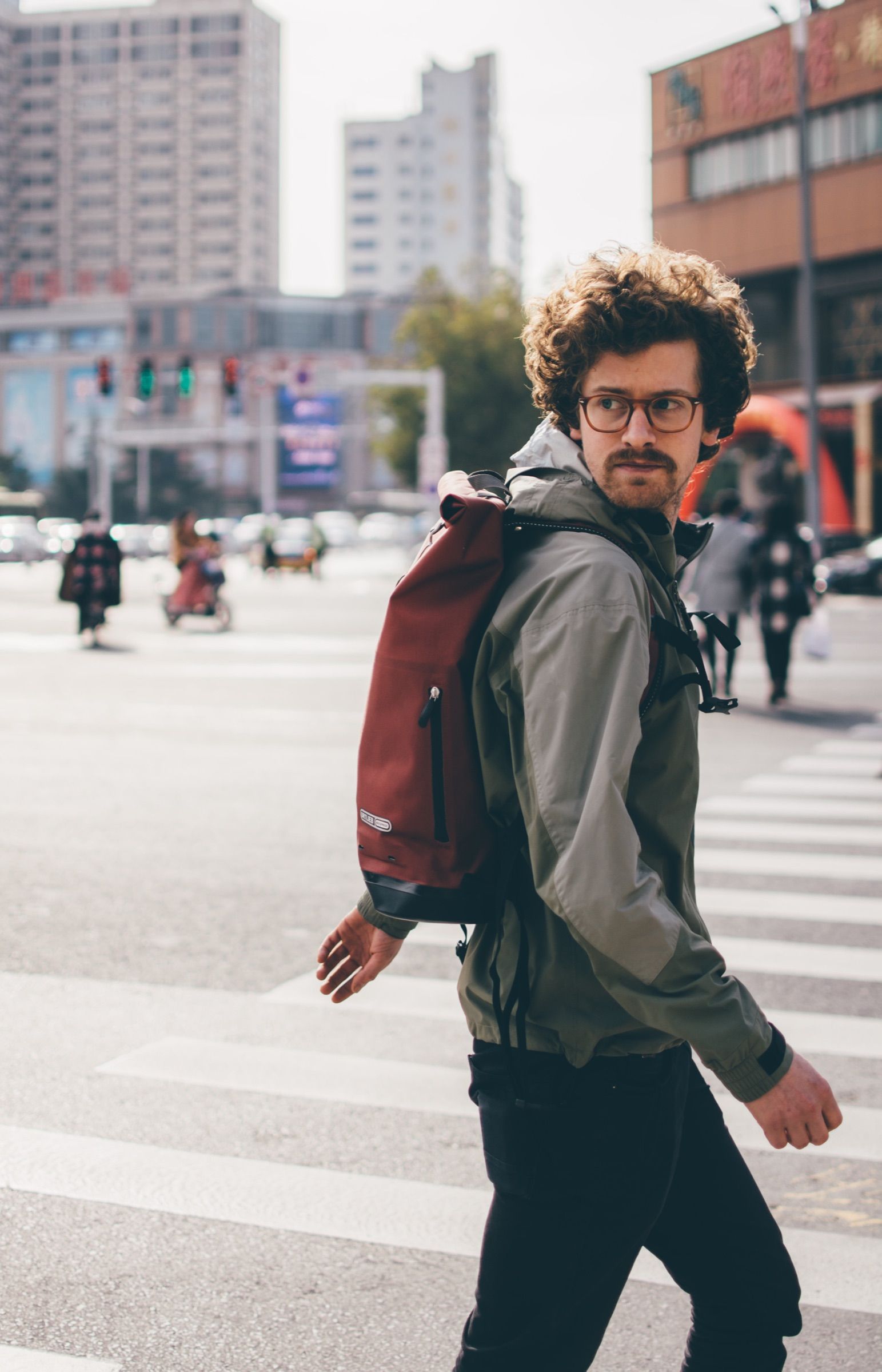 Traveler glancing back, Ortlieb backpack on their shoulders