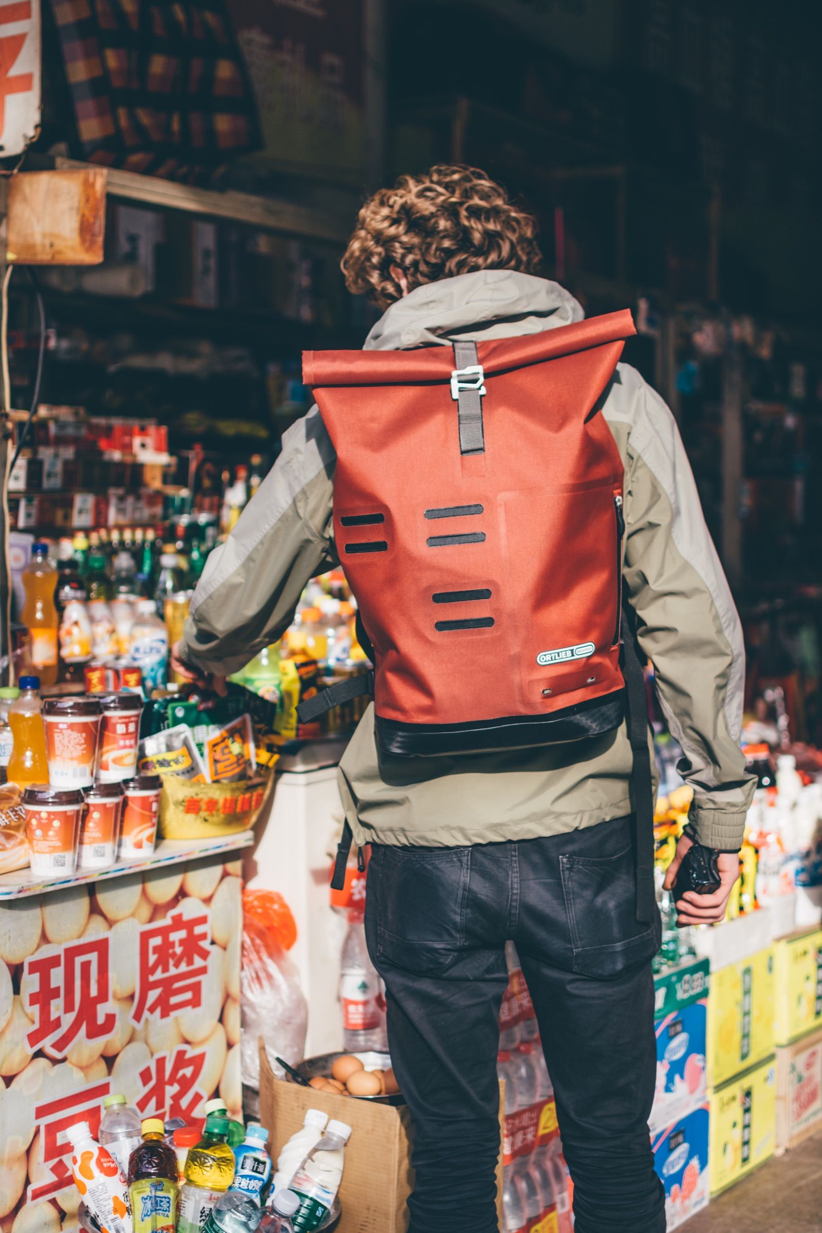Traveler with an orange Ortlieb backpack in the city
