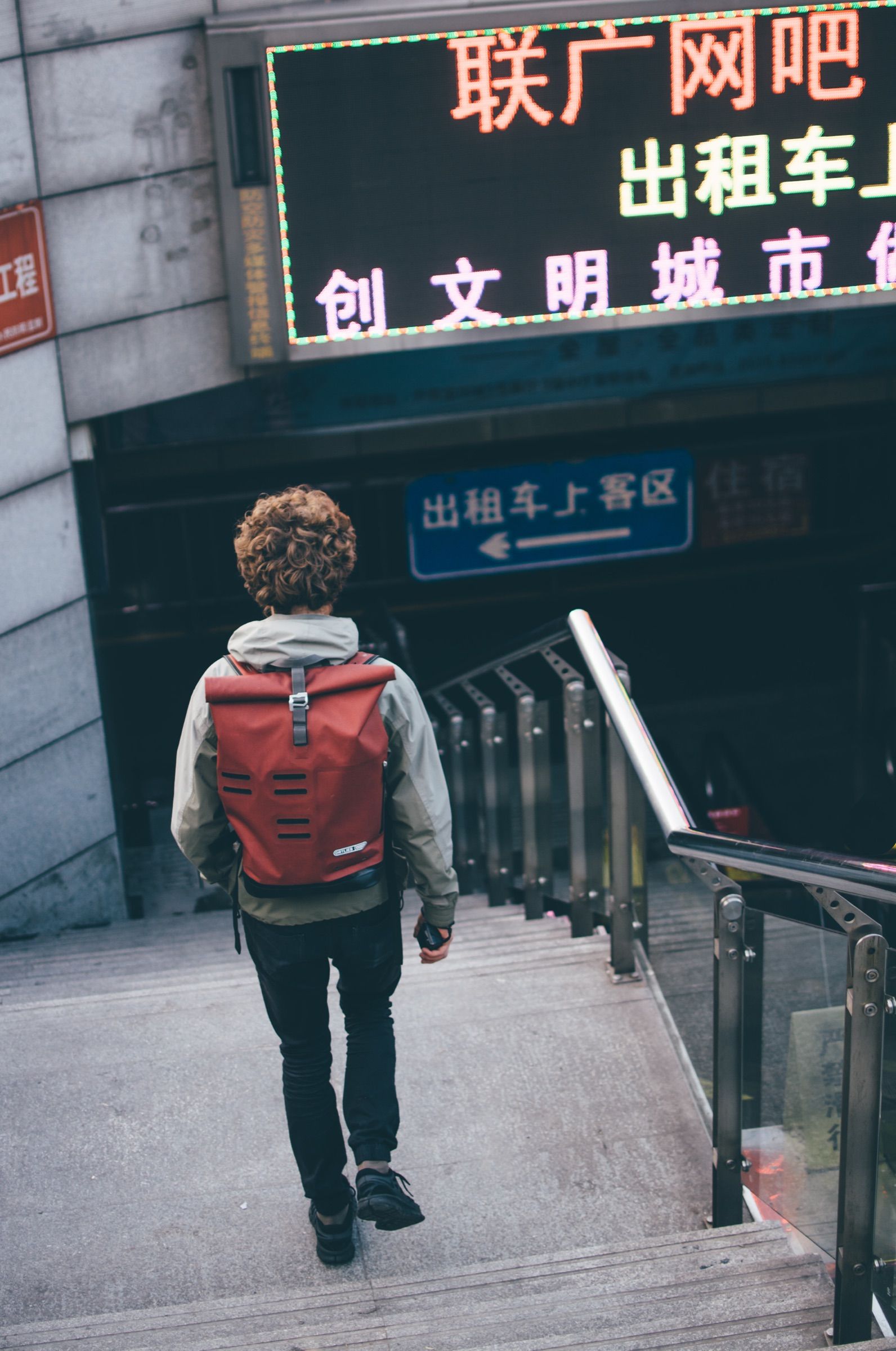 Traveler climbing city stairs with an Ortlieb backpack